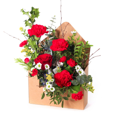 Letter to Santa (Red) - Send festive cheer straight to the heart with Letter to Santa (Red). A charming envelope-style arrangement filled with vibrant red blooms, fresh greenery, and seasonal accents. The perfect way to share Christmas joy in a truly unique design.